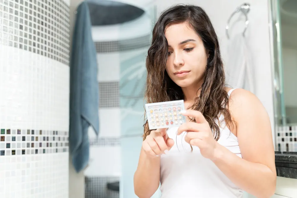 Woman holding a strip of contraceptive pills